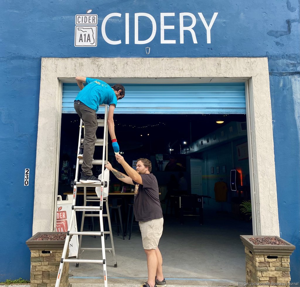 A1A Cidery Taproom sold to Philly Boyz Island Signs owner James Scarberry (top) and Joseph Penor remove signage from the A1A Cidery taproom in Fernandina Beach. The business has been sold to Philly Boyz, which plans to open a new location at the site. Submitted photo