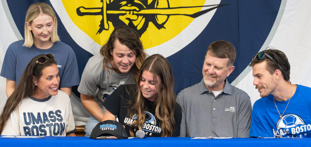 Charleston Knight signs while her family looks on. Photo by Penny Glackin/Special to Nassau NewsLine